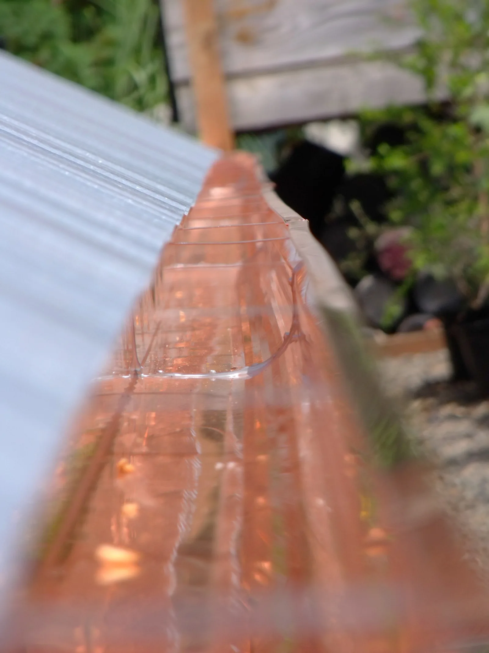 Close-up along a run of new copper gutter at a roof edge
